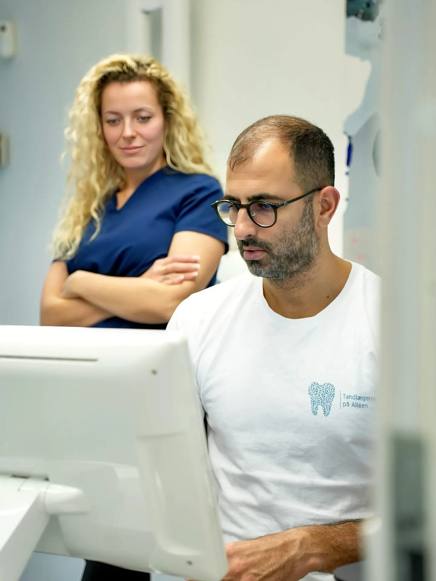 Tandlæge og klinikassistent gennemgår en digital scanning sammen